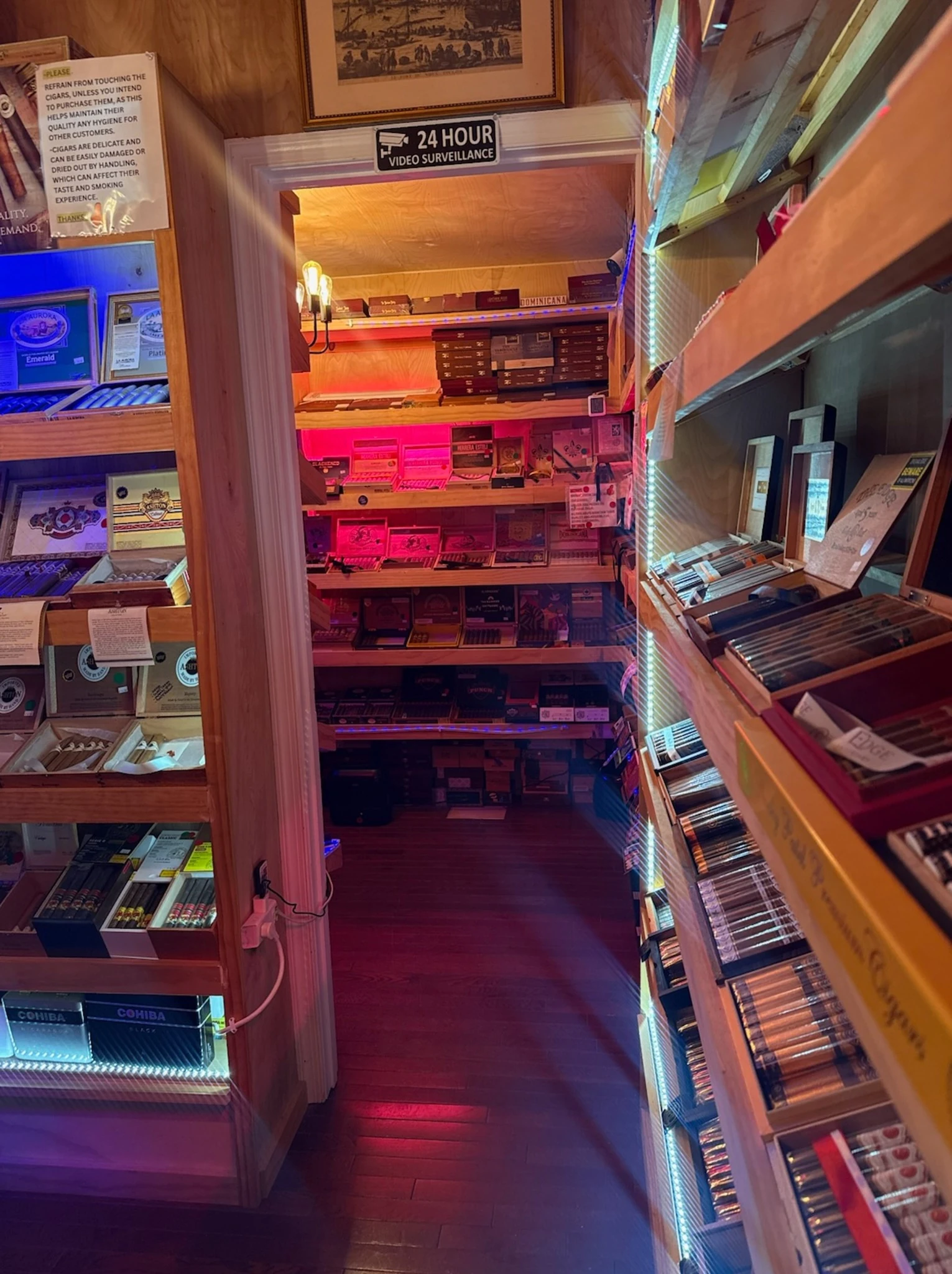 View into the walk-in humidor stock room at Reston Cigars & Vapes, shelves stacked with cigar boxes